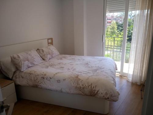 a bedroom with a bed and a large window at Apartamento Garcar in Murcia