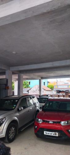 two cars parked in a parking lot under a bridge at HOTEL PANCHAVARNAA in Rāmeswaram