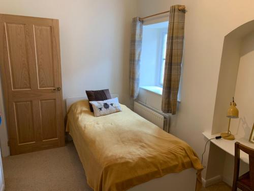 a small bedroom with a bed and a window at Eagle Cottage in Penrith