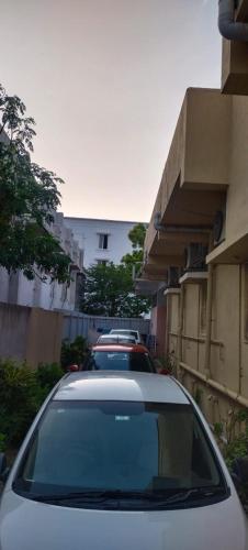 two cars parked in a parking lot next to a building at HOTEL PANCHAVARNAA in Rāmeswaram
