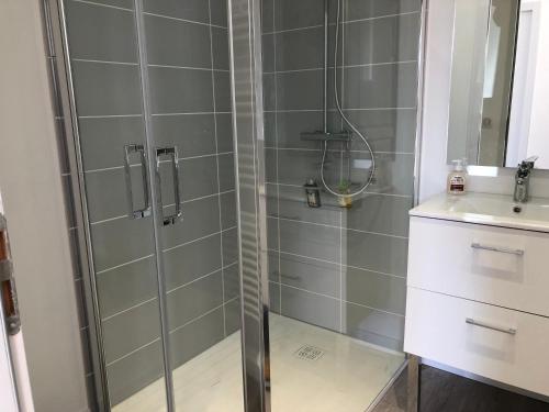 a shower with a glass door next to a sink at Sancerre Sunflower - Tournesol de Sancerre in Sancerre