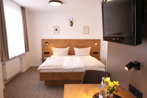 a hotel room with a bed and a table at Hotel Gasthof Jägerstüble in Freudenstadt