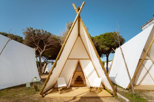trójkątny namiot teepee z krzesłami w obiekcie Kampaoh Trafalgar w mieście Los Caños de Meca