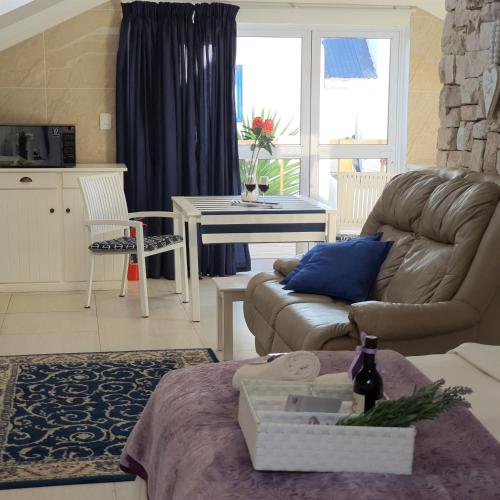 a living room with a couch and a table at LekkeBly Boutique Loft in Paternoster
