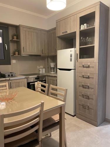 uma cozinha com uma mesa e um frigorífico branco em Iris Villas Complex em Lefkada