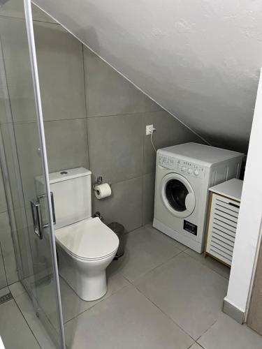 La salle de bains est pourvue de toilettes et d'un lave-linge. dans l'établissement Votsalo Corfu town apartment, à Ágios Rókkos