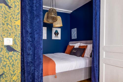 1 dormitorio con paredes azules y 1 cama con sábanas de color naranja en HONORÊ SUITE DU TEMPLE en Lyon