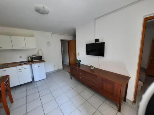 a kitchen with a table and a tv on the wall at Apartment Klementina FREE PARKING in Zagreb