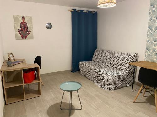 - un salon avec un canapé et une chaise dans l'établissement Studio cosy - Sainte-Clotilde, à Saint-Denis