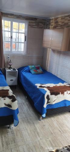 a bedroom with two beds with blue comforter at Playa, bosque y lago in Montevideo