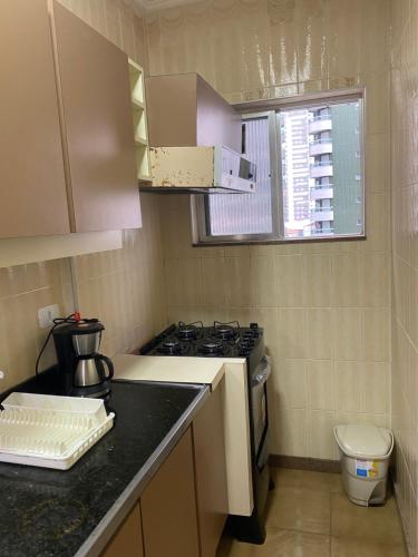 eine kleine Küche mit Herd und Spüle in der Unterkunft Pe na Areia Canto do Forte, Wi-Fi,Estacionamento in Praia Grande