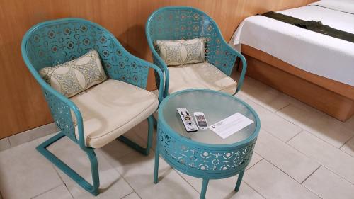 two chairs and a table in a room with a bed at Combate Beach Resort in Cabo Rojo
