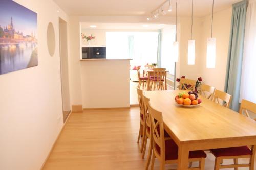 eine Küche und ein Esszimmer mit einem Holztisch und Stühlen in der Unterkunft Liebevoll renoviertes Haus mit großem Garten in Dresden in Dresden