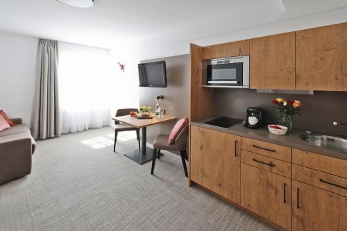 ein Hotelzimmer mit einer Küche und einem Tisch in der Unterkunft Hotel Gasthof Jägerstüble in Freudenstadt