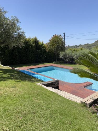 a swimming pool with a wooden deck in a yard at Les Columnes in Vespella de Gaià 