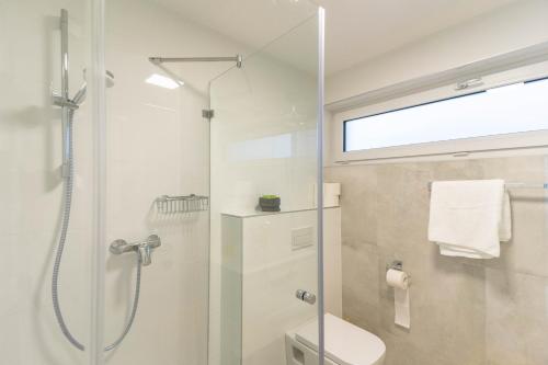 a bathroom with a shower with a toilet and a glass door at Izi Apartman in Fonyód