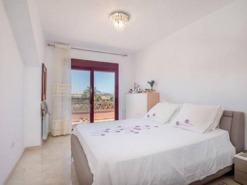 a white bedroom with a large bed and a window at Villa HEIDI in Málaga