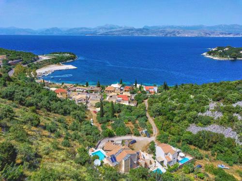 an aerial view of a house on a hill next to the ocean at Villa Spiros Imerolia Kassiopi in Kassiopi