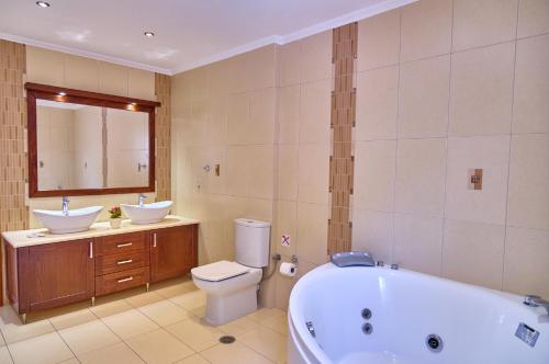 a bathroom with a tub and a toilet and a sink at Villa Spiros Imerolia Kassiopi in Kassiopi