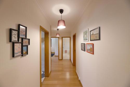 einen Flur mit vielen Bildern an den Wänden in der Unterkunft FLH Gaia Valadares Comfy Apartment in Vila Nova de Gaia