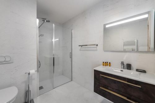 y baño con ducha, lavabo y espejo. en Perle de Savoie - Apt A103 - BO Immobilier, en Châtel