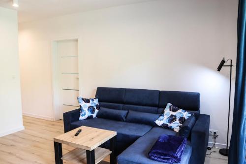 a living room with a blue couch and a table at Lemon Park Apartments Parking Gratis in Poznań