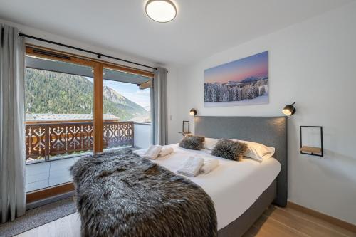 1 dormitorio con 1 cama grande y ventana grande en Perle de Savoie - Apt A103 - BO Immobilier, en Châtel