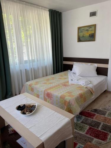 a hotel room with a bed and a bowl of food on a table at Guest House Liliya in Sozopol