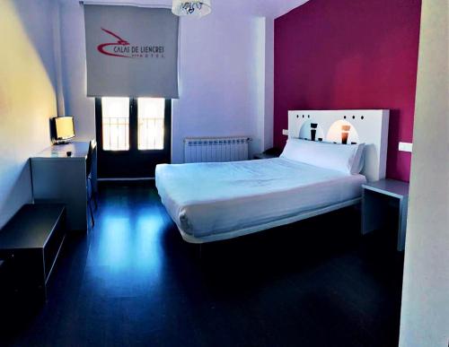 a bedroom with a large bed and purple walls at Calas De Liencres in Liencres