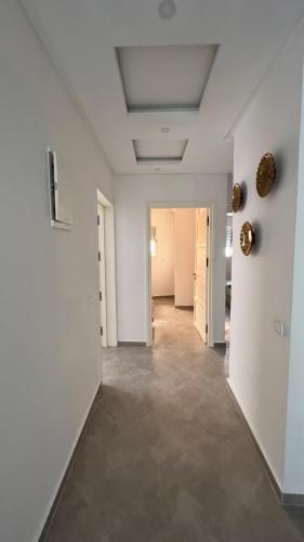 an empty room with white walls and a hallway at Tiwaline Tarsime App B in Sidi Ifni