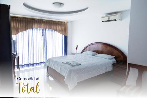 a bedroom with a large bed and a window at Hotel La Cascada - Lago Agrio in Nueva Loja