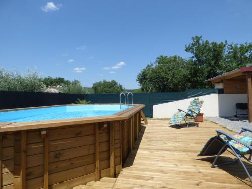 une terrasse au bord de la piscine avec un bain à remous et une terrasse avec des chaises dans l'établissement Les LOCS Du GRAZEL, à Ruoms
