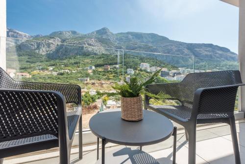 a table and chairs on a balcony with a view of a mountain at Luxury apartment EL Paradiso Sea & City view in Makarska