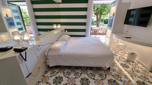 a bedroom with a bed and a desk and a television at Hotel Alpha in Sant'Agnello