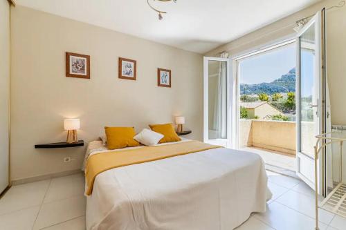 - une chambre avec un grand lit et une grande fenêtre dans l'établissement Villa Côté Sud, à Marseille