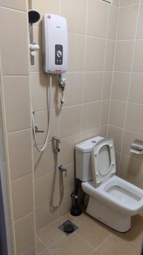 a bathroom with a toilet and a shower at PRESTIJ H0MESTAY in Balik Pulau