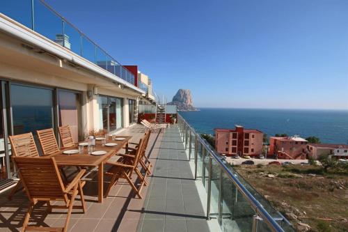 balcón con mesa, sillas y vistas al océano en Homeincalpe Borumbot, en Calpe