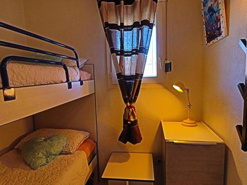 une chambre avec deux lits superposés et une fenêtre dans l'établissement Superbe 2P cabine climatisé, terrasse, piscine, Wi-Fi, parking - FR-1-472A-238, à Sète