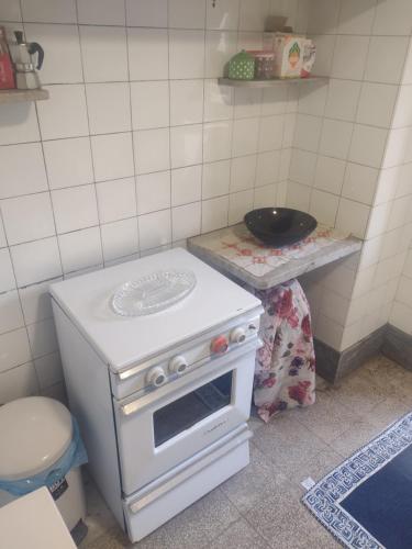 kuchnia z białą kuchenką i zlewem w obiekcie Casetta di fra w Katanii