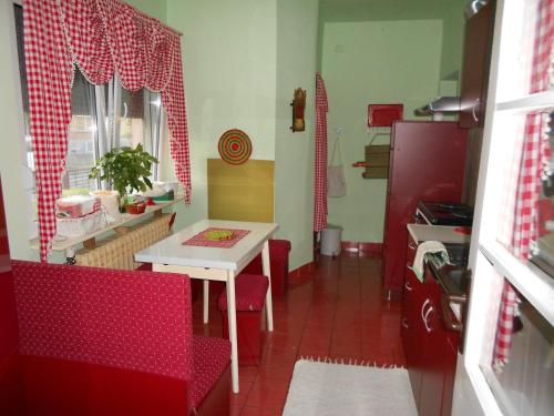 a small kitchen with a table and red chairs at Apartman "Dom Stankovića" in Pirot