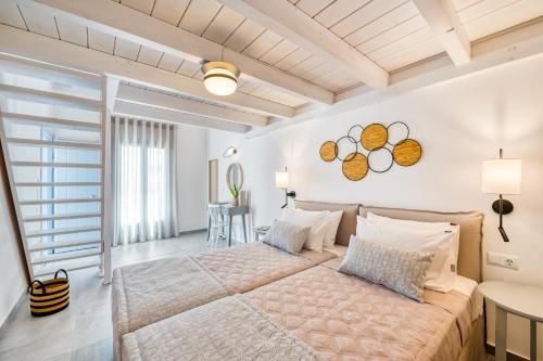 une chambre avec un grand lit dans une pièce dans l'établissement Lumiére spetses, à Spetses