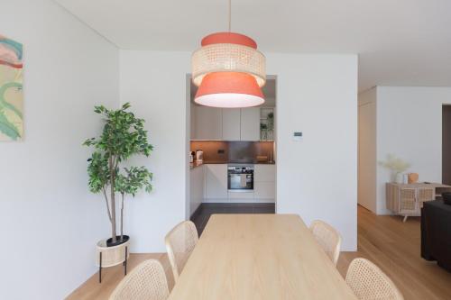 comedor y cocina con mesa de madera y sillas en FLH Amoreiras Wood Design Flat, en Lisboa