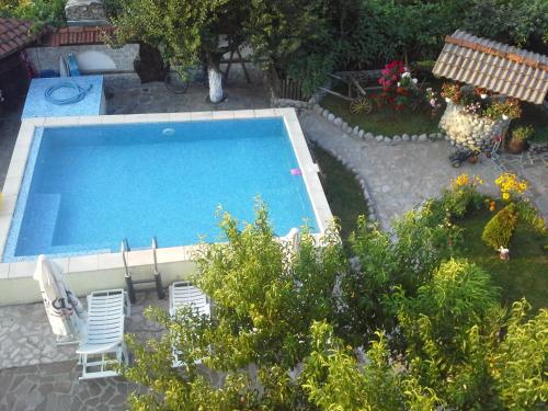 - une vue sur la piscine et ses 2 chaises dans l'établissement Старата Тонина къща, à Dobrinichte