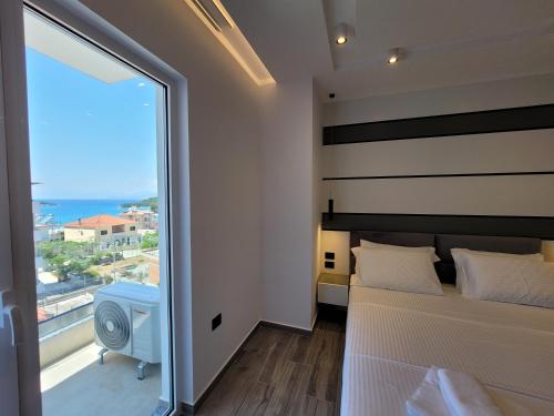 ein Schlafzimmer mit einem Bett und einem großen Fenster in der Unterkunft ADMIRO Hotel in Ksamil