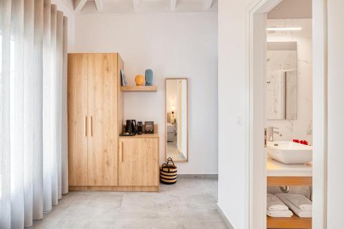 une salle de bain avec un lavabo et un miroir dans l'établissement Lumiére spetses, à Spetses