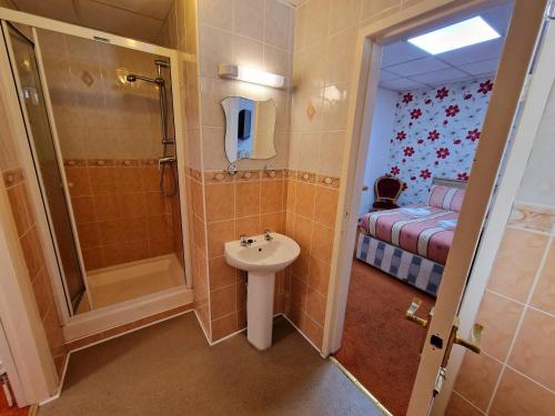 a small bathroom with a sink and a shower at The Albany hotel in Blackpool