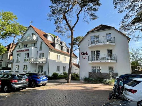a white building with cars parked in front of it at Haus Kiek Ut Apartment 26 in Timmendorfer Strand