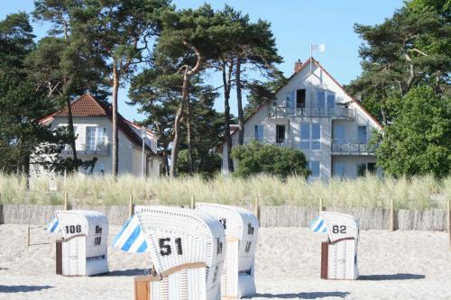 a row of beach chairs sitting on the beach at Haus Kiek Ut Apartment 26 in Timmendorfer Strand
