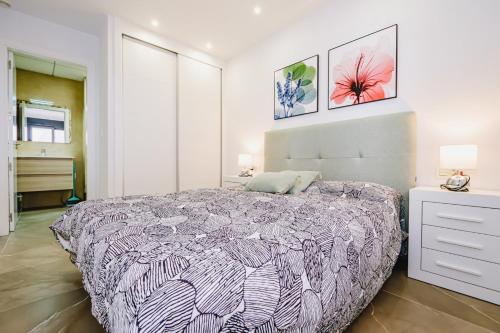 - une chambre avec un grand lit et deux photos sur le mur dans l'établissement Alegria ID 11, à Torrevieja