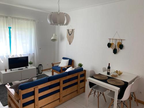 un soggiorno con divano blu e tavolo di Lovely and Cozy Quiaios 1 Bed Apartment a Palheiros de Quiaios
